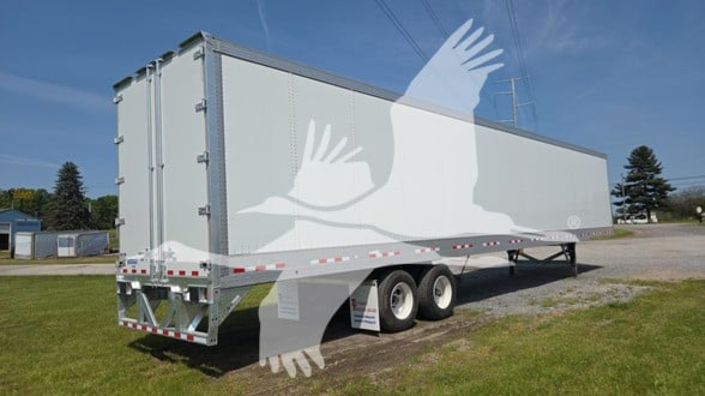 Trailer side view showing new Vanguard Vxp-High base rail trailer with dual wheels and long rectangular cargo area.