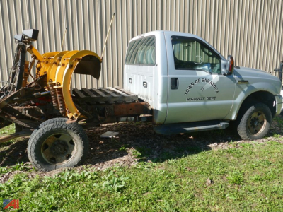 Ford F-350 Super Duty pickup with wheel loader snow plow attachment in bed, side view showing Town of Saratoga Highway Dept logo.