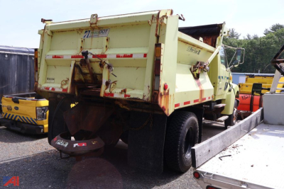 Dump truck rear view showing hydraulic dump bed and rear hitch, 2005 Sterling L8500 in-service with light yellow paint, red reflective stripes.