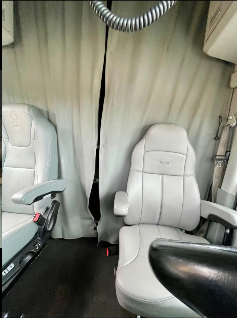 Kenworth T680 interior showing front seats and a curtain divider.