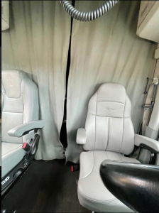 Kenworth T680 interior showing front seats and a curtain divider.