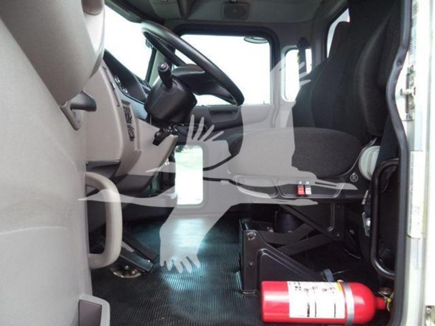 Truck cab interior of a 2022 Peterbilt 337 rollback showing driver seat, steering wheel, and fire extinguisher near floor.