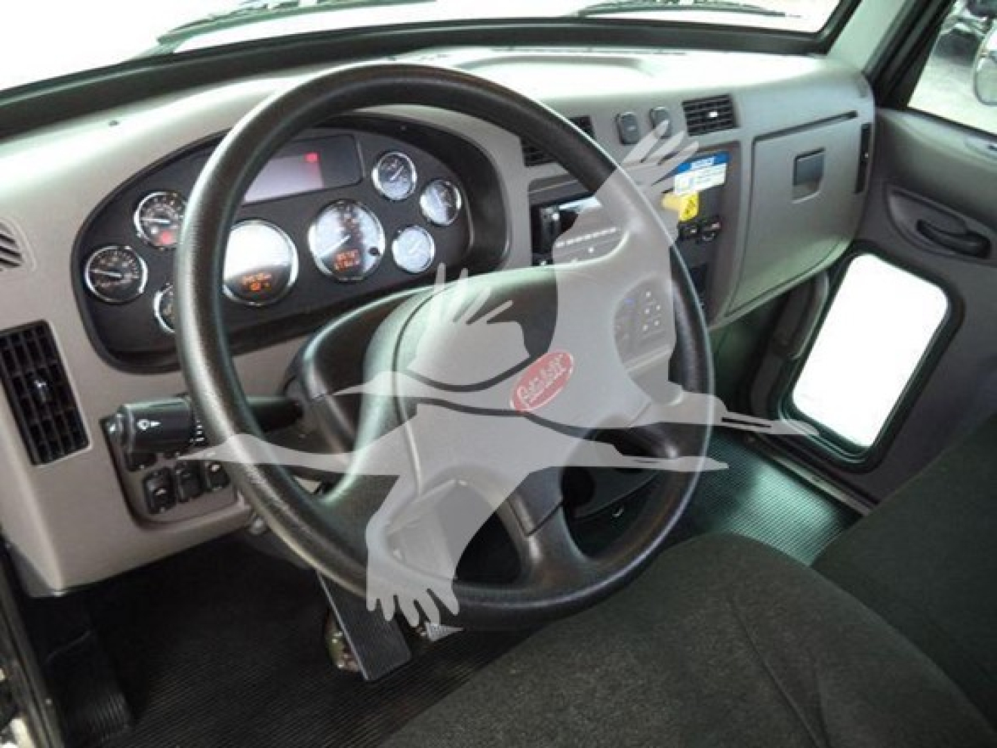 Peterbilt 337 cab interior showing steering wheel, gauge cluster, and dashboard with digital readouts.