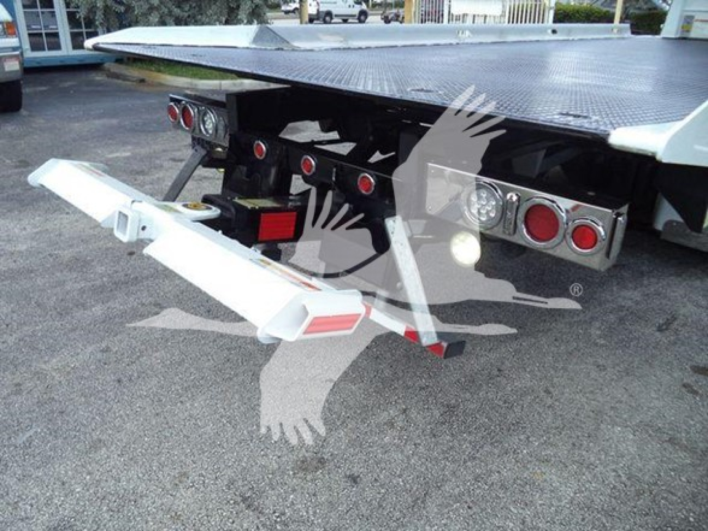 Peterbilt 337 rollback bed rear showing hydraulic tow equipment and lights with rear bumper, white painted components, metal platform in background.