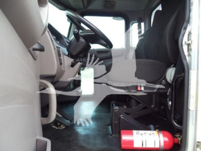 Truck cab interior of a 2022 Peterbilt 337 rollback showing driver seat, steering wheel, and fire extinguisher near floor.