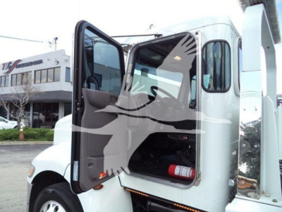 Truck cab interior/door area of a 2022 Peterbilt 337 rollback truck showing open door and storage area.
