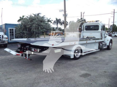 Peterbilt 337 rollback tow truck side view showing long flatbed and rear towing equipment.