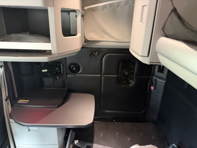 Kenworth T680 cab interior view showing sleeper area and storage compartments.