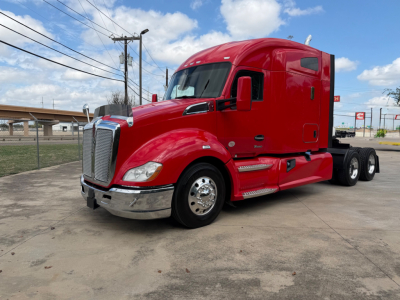 Kenworth T680 conventional sleeper truck in red, front three-quarter view with chrome bumper and dual rear axles.