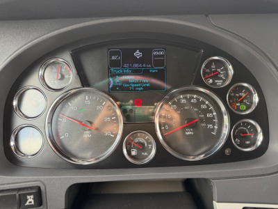 Kenworth T680 dashboard showing multiple gauges and a center digital display with truck info