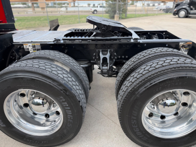 Kenworth T680 chassis with dual rear axles and chrome wheels, view of drive tires and seventh wheel area, no visible text.