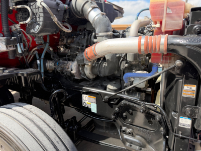 Kenworth T680 engine bay showing turbo, intercooler piping, coolant reservoir, and various hoses and components.