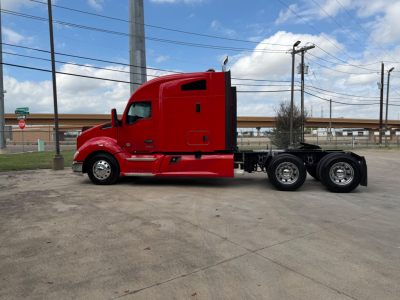 Kenworth T680 heavy-duty truck in red, side view showing tractor cab and rear axles, no trailer attached.