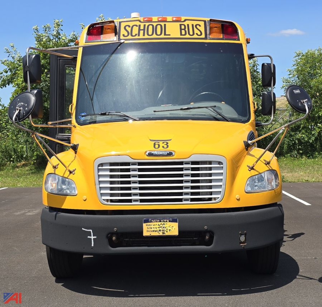 Bus front view showing yellow Freightliner Thomas logo grille, hood number 63, school bus sign, and black bumper.