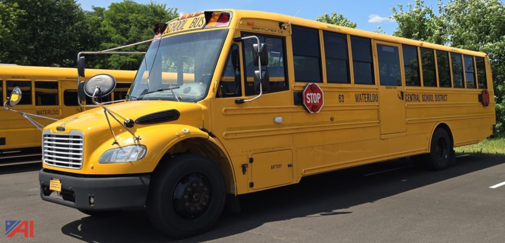 Yellow Freightliner Thomas B2 C2 school bus side view showing stop sign, warning lights, and text along bus