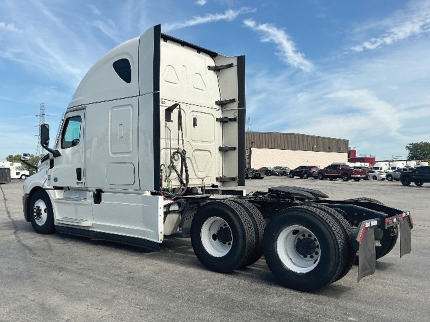 Freightliner Cascadia126 tractor in white, side view showing sleeper cab, rear wheels, and chassis.