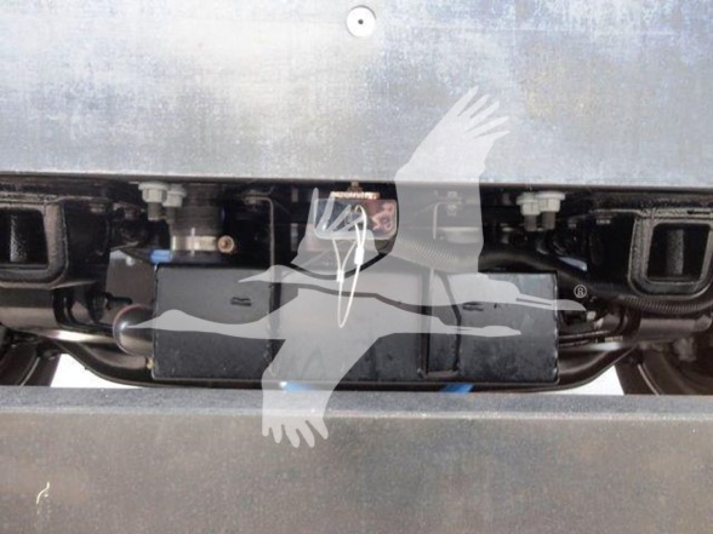 Truck engine bay with electrical harnesses and grille area visible; no specific text legible.