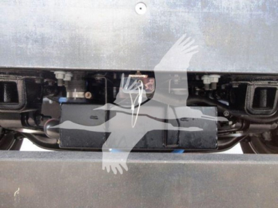 Truck engine bay with electrical harnesses and grille area visible; no specific text legible.
