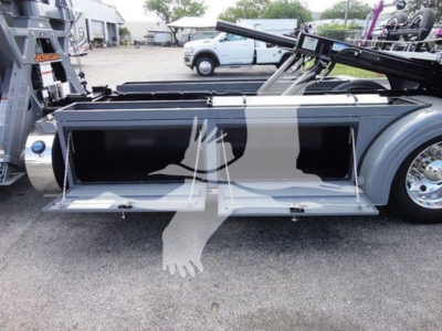 Peterbilt 337 rollback truck side storage compartment open revealing empty toolbox and aluminum cabinet.