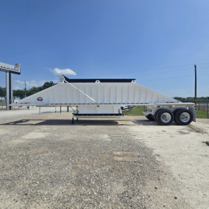 Dump trailer with air suspension and dual-axle rear; side profile shows long white trailer with triangular nose, tag and wheelset. Visible text: none legible on trailer side.