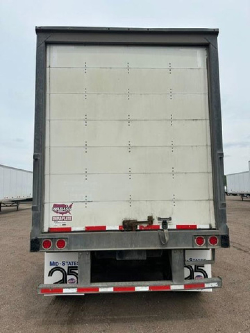 Rear view of a used 2016 Wabash van trailer showing closed rear doors, bumper, taillights, and reflective tape.