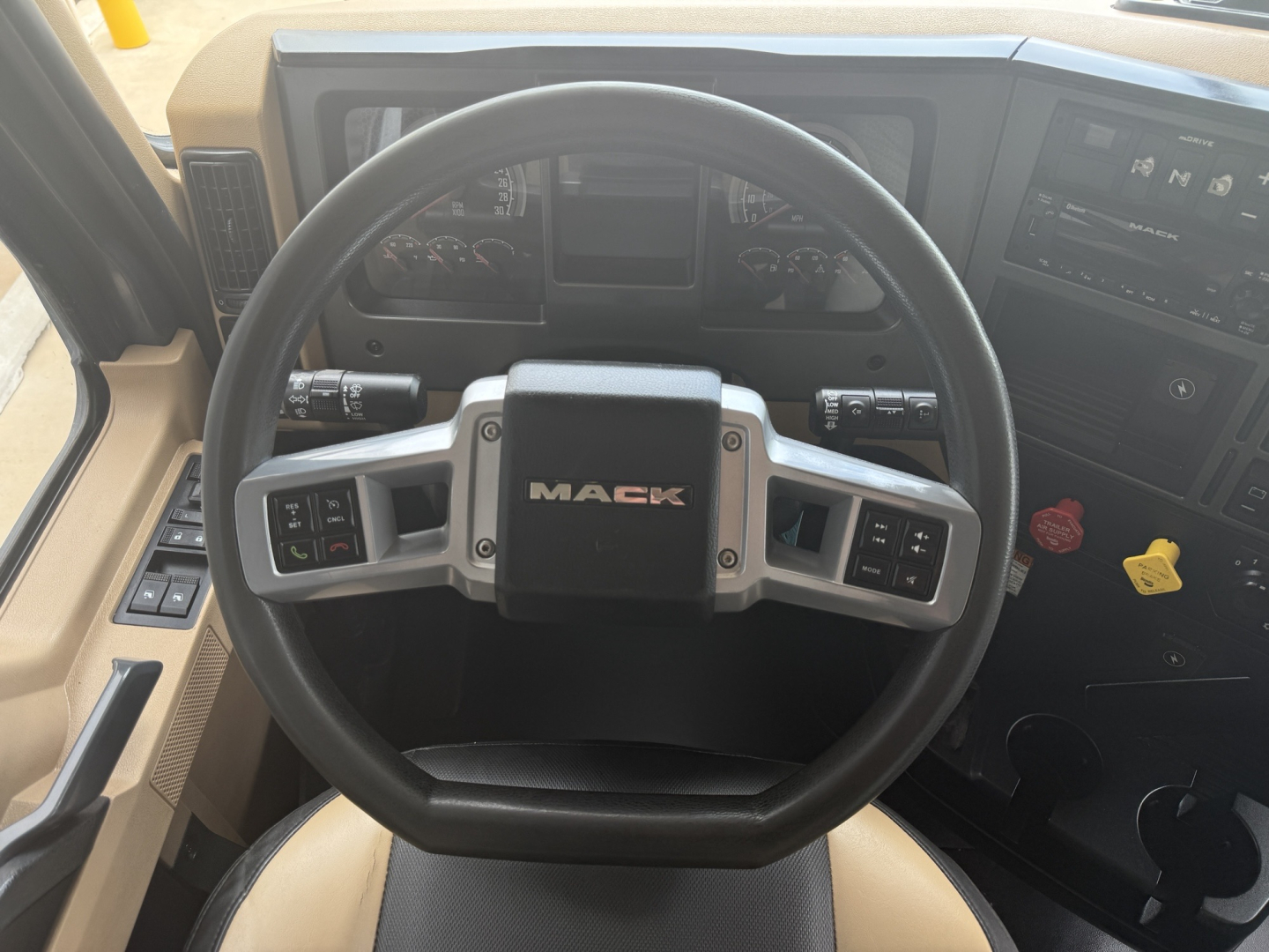 Mack steering wheel and dashboard in cab showing Mack logo on the steering wheel and instrument cluster