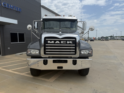 Front view of a 2023 Mack GR64F dump truck showing large chrome grille with MACK lettering, dual headlights, and chrome bumper.