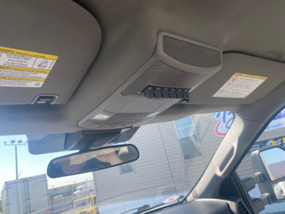 Ford cabin interior showing overhead console with warning labels and rearview mirror.
