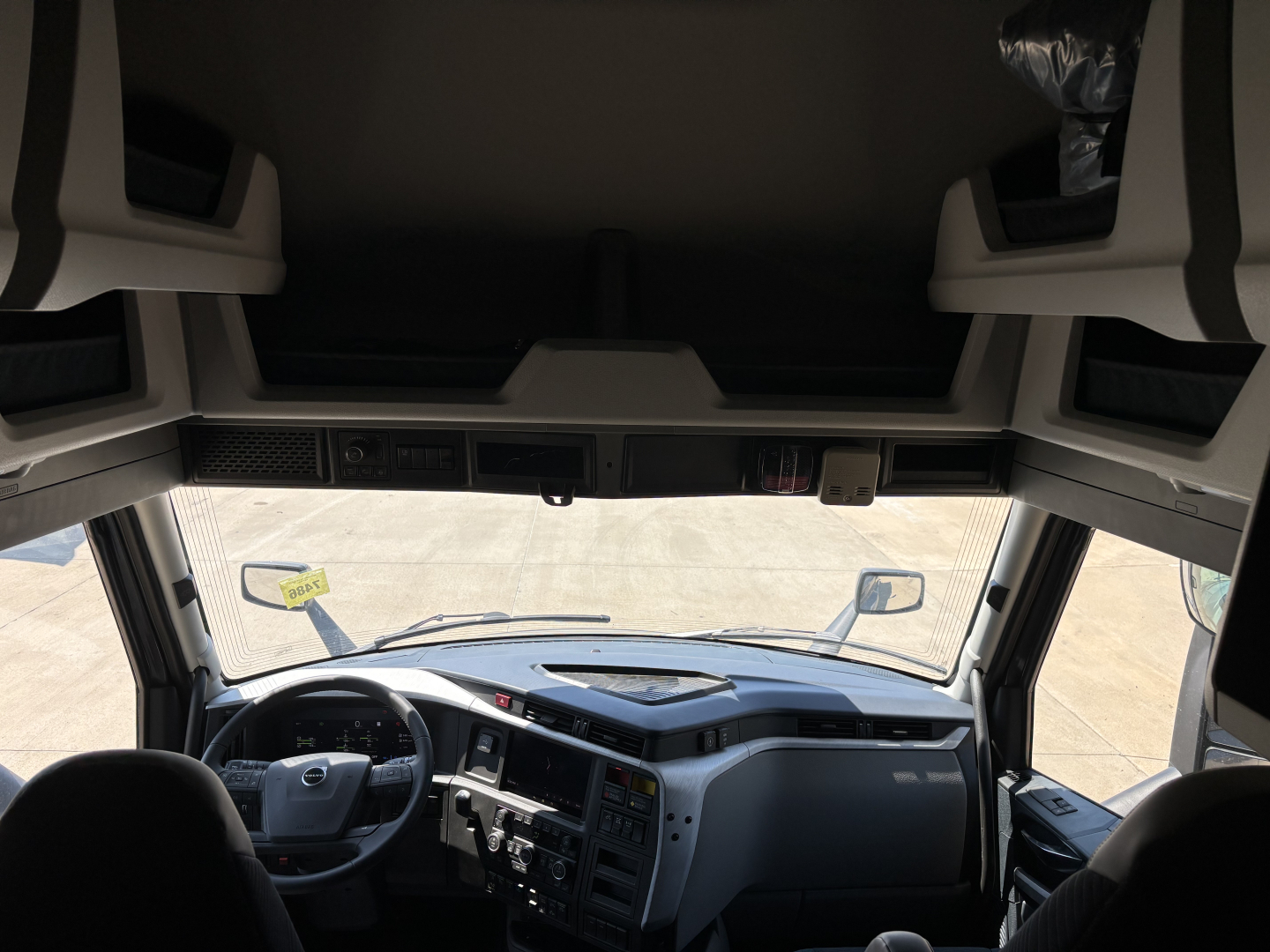 Interior cab view of a Volvo VNL64T860 truck from the driver seat, with dashboard and steering wheel visible.