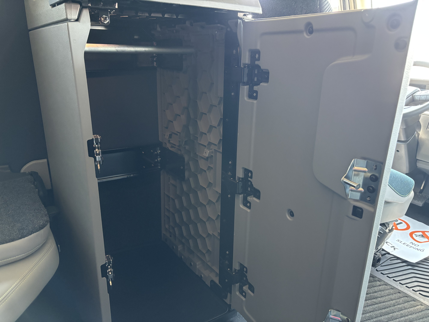 Volvo VNL64T860 cab interior scene showing open storage cabinet with multiple shelves and interior panels.