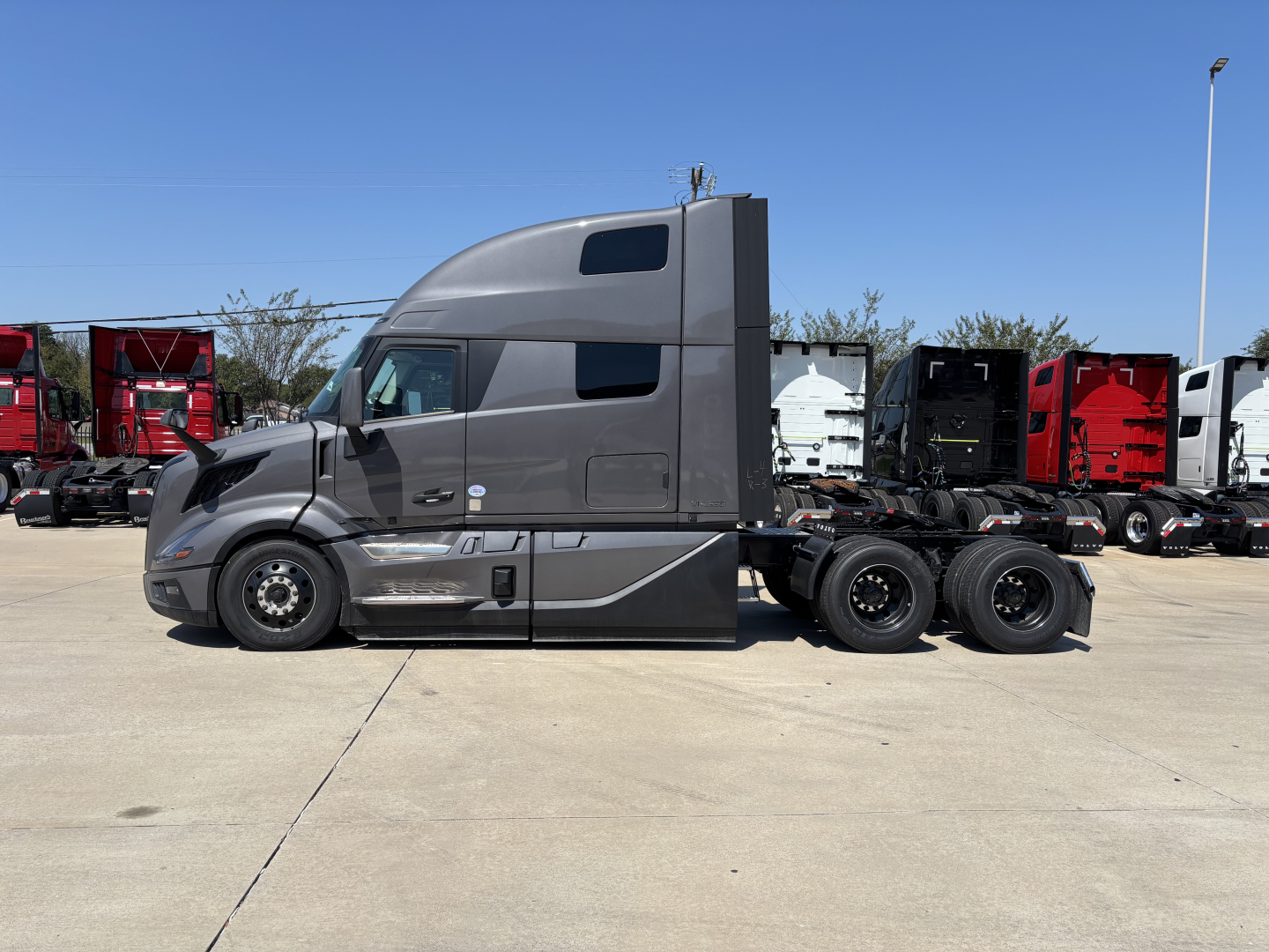 Volvo VNL64T860 sleeper cab tractor in profile view showing side with gray paint and aerodynamic fairings.