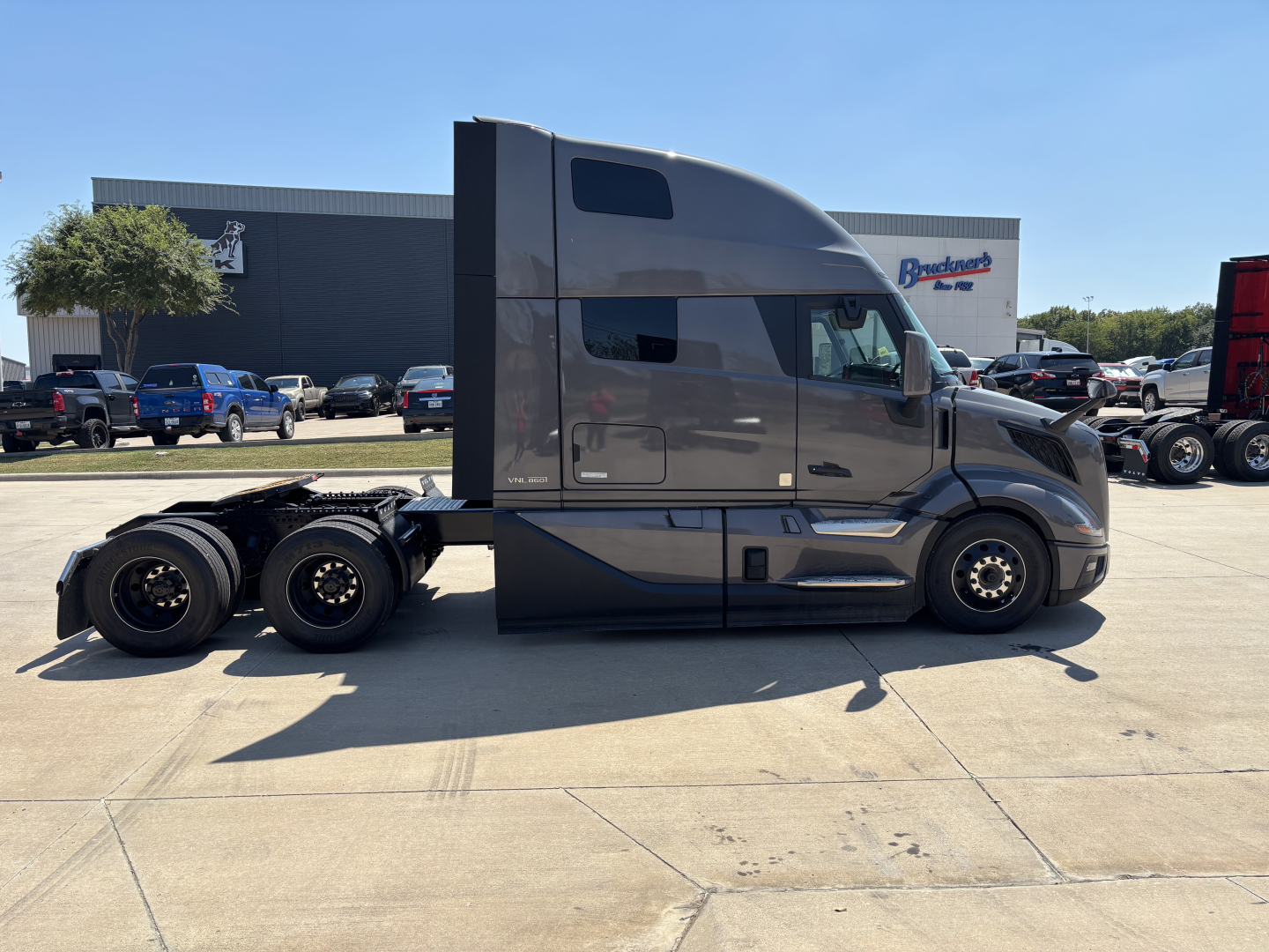 Volvo VNL64T860 tractor-trailer side view showing aerodynamic sleeper cab and dual rear axles.