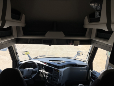 Interior cab view of a Volvo VNL64T860 truck from the driver seat, with dashboard and steering wheel visible.