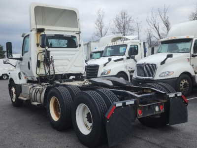 Truck chassis from a 2018 International LT625 with fifth wheel removed, dual rear axles, white wheels, and cab in the background.