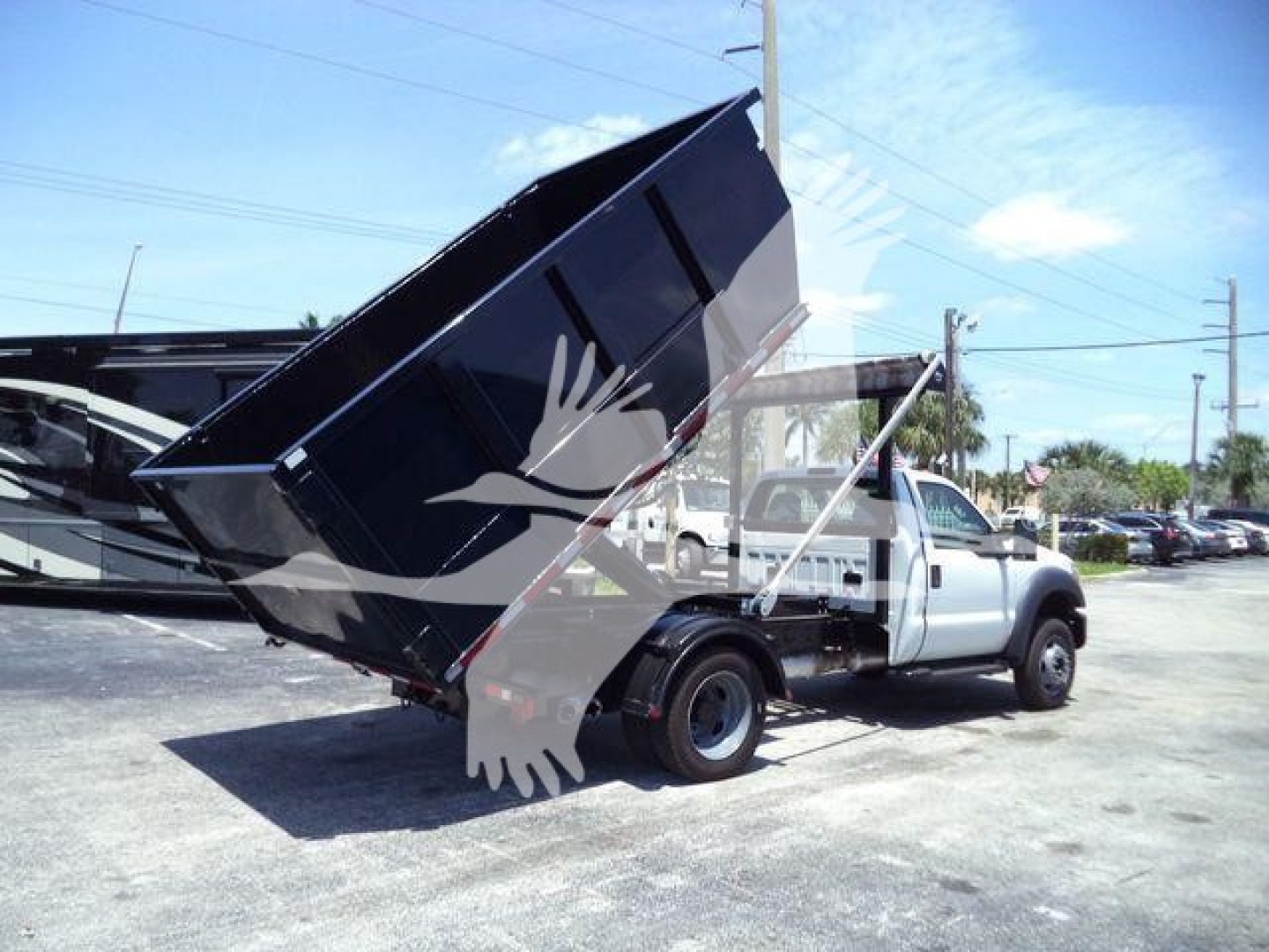 Ford F-550 dump truck with raised black dump bed in a dealership lot. Visible text on image is not legible; no stickers readable.