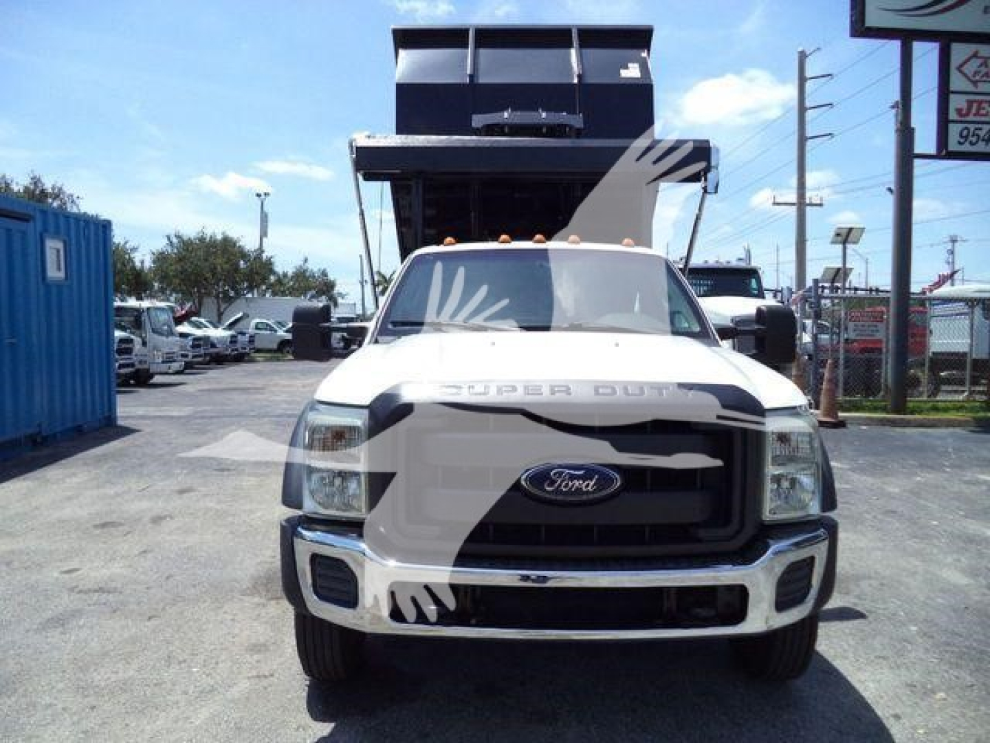Ford F-550 dump bed truck in front view with raised bed and logo visible. Front grille, headlights, bumper, and Super Duty badge.
