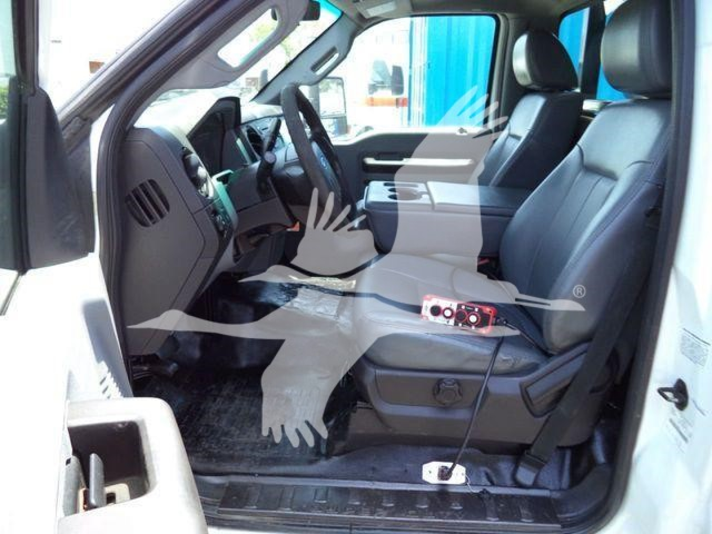 Ford F-550 truck interior front seat view showing driver and passenger seats, steering wheel, center console, and floor mats.