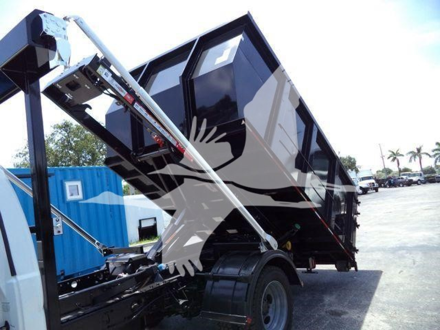 Ford F-550 dump truck bed in raised position showing hydraulic lift and cargo container.