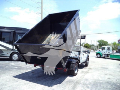Ford F-550 dump bed truck with hydraulic dumper raised, visible text not legible on components.