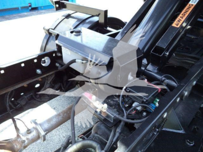 Truck hitch area showing hydraulic cylinder and wiring on a 2016 Ford F550 roll-off chassis.