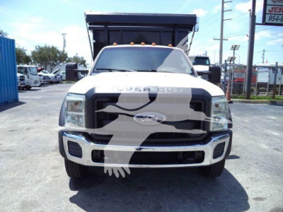 Ford F-550 dump truck front view with 'FORD' emblem, chrome grille, headlights, and dump bed in the background.
