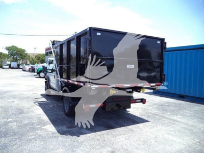 Truck bed or dump body mounted on Ford F-550 rear view showing black roll-off container.