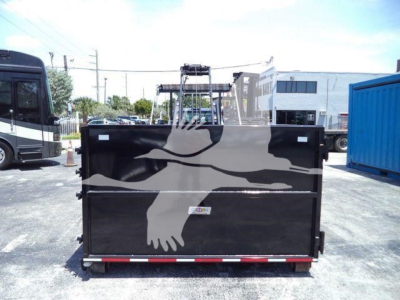 Rolloff truck bed with black paint and a large white eagle graphic on the back, roadside lot.