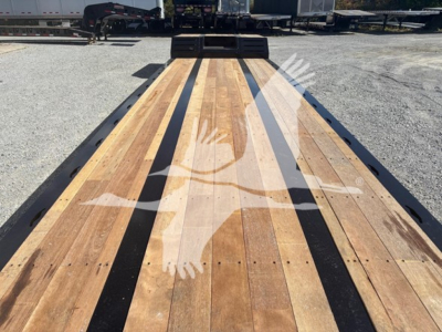 Flatbed trailer deck with wooden planks and black steel edge, Fontaine N20 pony motor trailer in a yard.
