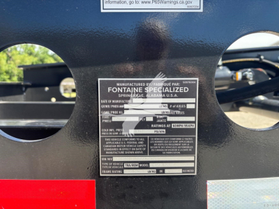 Label plate on Fontaine Renegade N20 lowboy trailer showing manufactured by Fontaine Specialized with details like GVWR, axle configuration, and VIN area.
