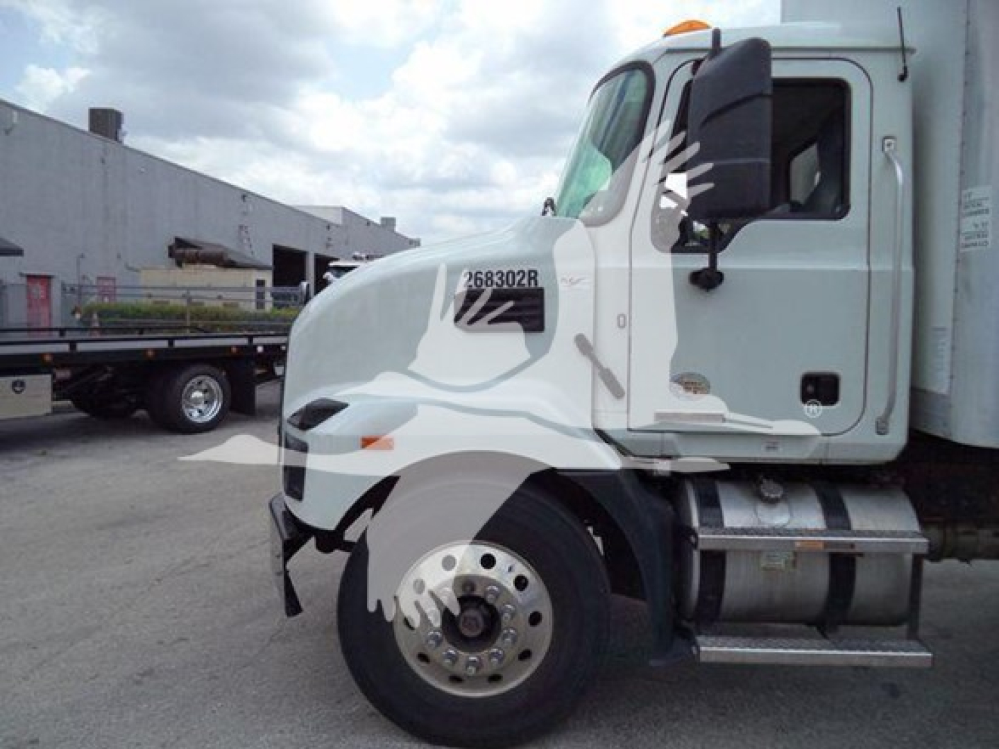 Truck cab of a 2023 Mack MD7 in a used category showing stock number 268302R on the door area.