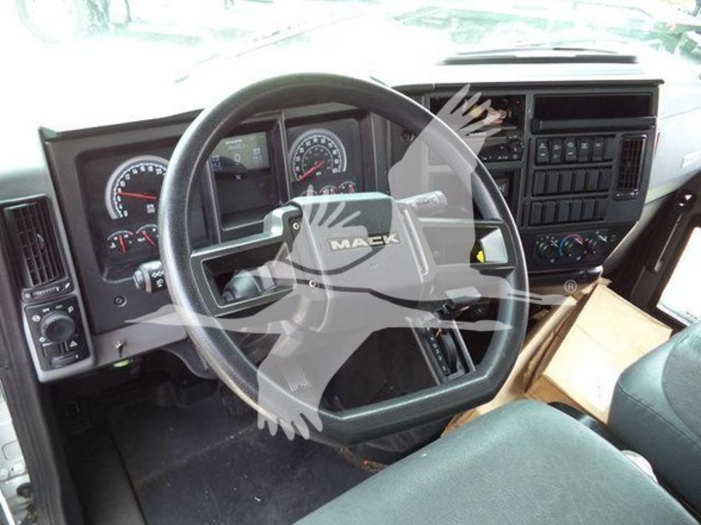 Mack MD7 cabin interior showing steering wheel and dashboard gauges.
