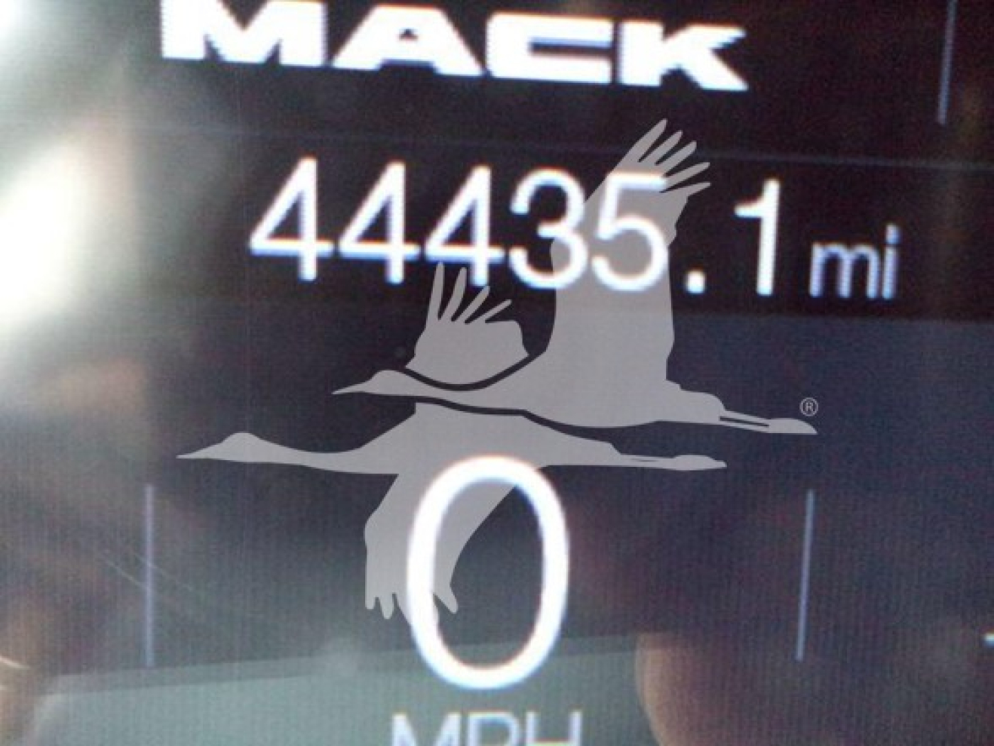 Mack Md7 truck dashboard display showing 44,435.1 miles and 0 mph with partial Mack logo. 