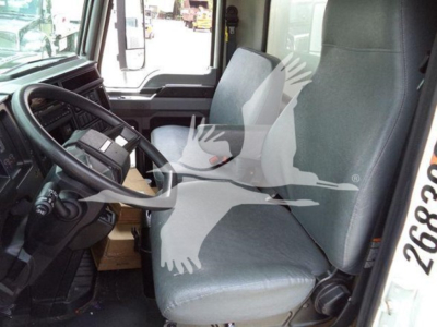 Cab interior of a Mack MD7 truck showing driver's seat and dashboard with steering wheel.
