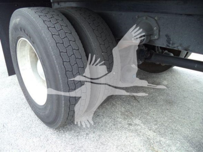 Rear dual tires on Mack MD7 truck axle showing wheel hub and suspension component.